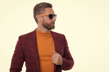 Şık ve modaya uygun. İspanyol manken. Beyaz giysili şık erkek kıyafetleri. İş ceketli ve güneş gözlüklü bir adam. Olgun adam erkek giyim tarzı giyinir. Boşluk afişini kopyala.