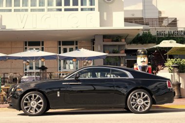Miami, Florida, ABD - 09 Aralık 2024: siyah 2018 Rolls Royce Wraith arabası. Rolls Royce Wraith 'in lüks arabası. Rolls Royce Wraith 'in arabası dışarıda park edilmiş. Rolls Royce Wraith, yan görünüm.