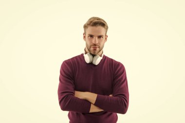 Sıradan bir erkek portresi. Milenyum portresi. Genç adam beyazda izole edilmiş. Kulaklıklı şık bir genç adam portresi. Sıradan bir adam. Adamın şık bir kazağı var. Gündelik kazak giyen genç adam..