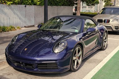 Miami, Florida, ABD - 11 Aralık 2024: Mavi Porsche 911 üstü açık araba. Porsche 911 tipi üstü açık lüks bir araba. Porsche 'nin arabası dışarıda park edilmiş. Porsche, köşe görünümü.
