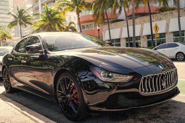 Miami, Florida, ABD - 17 Aralık 2024: Black 2014 Maserati Ghibli spor yara izi. Maserati Ghibli 'nin lüks spor arabası. Maserati Ghibli 'nin arabası dışarıda park edilmiş. Siyah Maserati Ghibli, köşe görünümü.