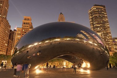 Chicago, Illinois, ABD - 22 Ekim 2024: Millennium Park ve ünlü Cloud Gate heykeli. Fasulye heykeli. Gökdelenli gece şehri manzarası. Chicago Milenyum Şehir Parkı. Bulut Kapısı.