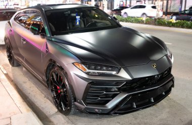 Miami, Florida, ABD - 8 Nisan 2025: lüks turuncu SUV araba Lamborghini Urus. Lamborghini Urus 'un arabası dışarı park edilmiş, köşe manzaralı. Lamborghini Urus 2021 lüks SUV Gri Matt rengi.