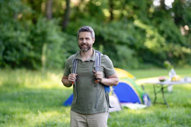 Ormandaki çadırda yetişkin bir yürüyüşçü. Sırt çantalı bir gezgin. Yürüyüş macerası. Seyahat yaşam tarzı. Kırsalda yürüyüş yapan bir adam. Ormandaki İspanyol adam. Sırt çantalı bir yürüyüşçü ormanda yürüyüş yapıyor..