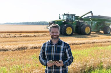 Tablet çekli İspanyol çiftçi. Ekin hasadı. Tarlada tableti olan çiftçi tarımcı adam. Modern tarımın teknolojisi. Tarlada tabletle çalışan çiftçi. Toprak analisti.