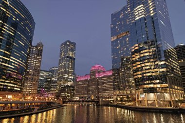 Nehirdeki Chicago gökdelenin mimarisi. Şehir gecesi aydınlatılmış bina. Gökdelen şehir manzarası. Chicago, Illinois 'de bir gece şehri. İş şehri. Chicago gökdelen binasının gece manzarası.
