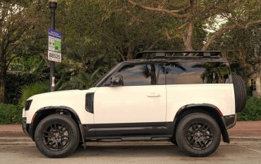Miami, Florida, ABD - 08 Aralık 2024: 2023 Land Rover Defender SUV pikap kamyonu. Land Rover Defender 'ın lüks SUV arabası. Land Rover 'ın arabası dışarıda park edilmiş. Land Rover Defender, yan görünüm.