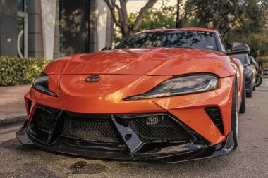 Miami, Florida, ABD - 26 Kasım 2024: Toyota Supra spor arabası. Toyota Supra turuncu renkli lüks spor araba. Toyota Supra 'nın arabası dışarıda park edilmiş. Toyota Supra, alçak görüş..