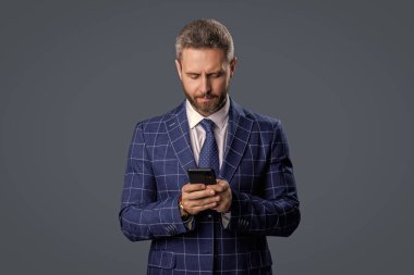 Telefon kullanan bir iş adamı. Gri yolda insan telefonu görüşmesi izole edildi. İş adamı sohbeti. İş adamı mesajlaşması ve mesajı. Sosyal ağ. Telefonu olan İspanyol bir iş adamı..