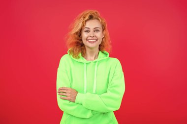 Pembe kapüşonlu bir kadın. Moda modeli. Şık kapüşonlu kızıl saçlı kız. Sıradan kapüşonlu, şık, beyaz bir kadın. Modayla ilgilenen kız modaya uygun ve parlak görünüyor. Çabasız cazibe.