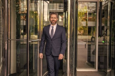 Takım elbiseli adam ofise yürür. Ofis binasındaki İspanyol işadamı. Dışarıda başarılı bir iş adamı. Şehir caddesinde yürüyen bir adam. Takım elbiseli bir iş adamı. İş adamının iş başarısı. Buluşma ortağı.