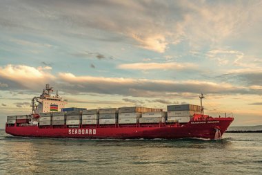 Miami, Florida, ABD - 3 Ocak 2025: Gündoğumunda konteyner gemisi. Kargo gemisi Seaboard Genesis ve konteynır Miami 'de. Yük konteynırı kargo gemisine yüklendi. Hava görüntülü kargo gemisi limana giriyor..