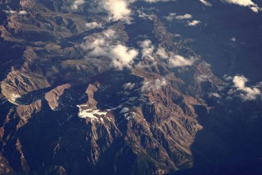 Bulut ve dağ zirvesi hava manzarası. Dağ manzarasının havadan görünüşü. Hava bulutlu görünüyor. Uçaktan manzara. Dağların tepesinde, bulutların içinde. Dağ manzaralı güzel bulutlu doğa.