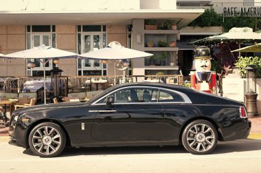 Miami, Florida, ABD - 09 Aralık 2024: siyah 2018 Rolls Royce Wraith arabası. Rolls Royce Wraith 'in lüks arabası. Rolls Royce Wraith 'in arabası dışarıda park edilmiş. Rolls Royce Wraith, yan görünüm.