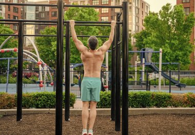 Kas kasları ve trisepsler. Güçlü bir atlet. Adam yanaşıyor. Güçlü sırt kası olan kaslı bir sporcu. Spor barfiks egzersizi. Spor eğitimi. Sporcu adam egzersiz yapıyor. Rutini göster.