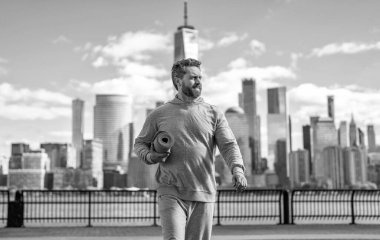 Manhattan 'da spor kıyafetli bir adam. Vücuduna uygun. Yoga koçu. Sporcu adam antrenmana hazır. Sağlıklı bir yaşam tarzı. Spor ve spor. Eğitim için yoga minderi. New York 'ta sporcu.