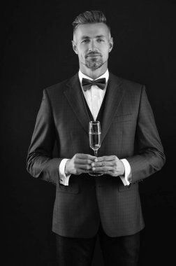 Şampanyayla kutlayın. Kutlama ve tezahürat. Smokinli bir şarap garsonu. Şık smokinli adam siyah üzerine izole edilmiş şampanya bardağı tutuyor. Başarıyı kutluyoruz. - Şerefe. Smokinci adam resmi görünüyor..