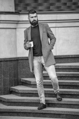 Günlük stil rutini. Sakallı adam şehir caddesinde kahve içiyor. Sokakta elinde kahve tutan yakışıklı bir adam. İş molası. Sabah kahvesi içen adam. Kahve molası. Binadan çıkıyorum..