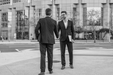 İki işadamı iş anlaşmasını kutluyor. İş anlaşmasında başarılı bir ortaklık. İş adamları dışarıda iş yapıyor. Ortaklık başarısı. İş ortaklığımızı kutlayalım. Diplomasi.