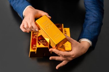 Fon başarısı. Altını olan başarılı zengin bir adam. Altın külçeli iş adamı. Yatırım ve tasarruf. Altın külçe. Altın çubuk. Zengin işadamı altın külçelerini biriktirir. Gelecek için kaydediliyor.