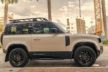 Miami, Florida, ABD - 08 Aralık 2024: 2023 Land Rover Defender SUV pikap kamyonu. Land Rover Defender 'ın lüks SUV arabası. Land Rover 'ın arabası dışarıda park edilmiş. Land Rover Defender, yan görünüm.