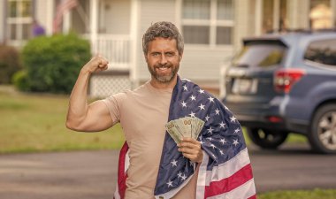 Amerikan bayrağı ve dolar parası olan adam. Enflasyon konsepti. Amerikan vergi politikası. İspanyol adam ve Amerikan bayrağı. Amerika 'da vergi ödemek. Katma değer vergisi. Vergi sistemi. Vatansever güçlü adam.