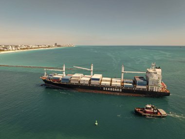 Miami, Florida, ABD - 20 Mart 2025: Miami deniz limanı. Monrovia konteynırı gemisi. Kargo Seaboard Explorer konteynır gemisi, hava manzaralı. Yük konteynırı kargo gemisi ve römorkör. Kargo gemisi.