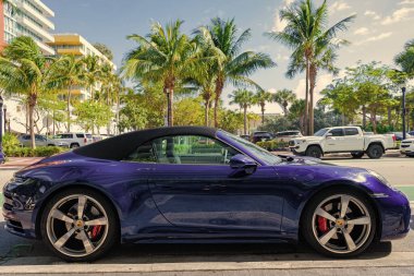 Miami, Florida, ABD - 11 Aralık 2024: Mavi Porsche 911 üstü açık araba. Porsche 911 tipi üstü açık lüks bir araba. Porsche 'nin arabası dışarıda park edilmiş. Porsche, yan görünüm.