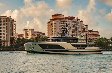 Marinaya yüzen bir tekne. Fisher Adası 'nda lüks bir yat teknesi. Yaz tatili. Fisher Adası konut binası ve lüks yat teknesi. Miami Fisher Adası Panorama Manzarası.