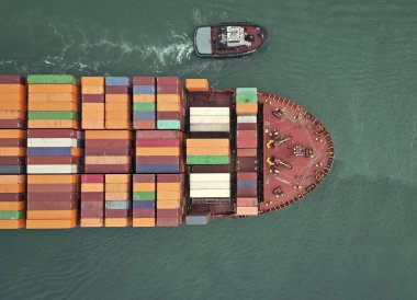 Kargo gemisi limandan ayrılıyor. Konteyner gemisi. İhraç ve ithalat. Kargo işi. Nakliye lojistiği. Konteynırlı kargo gemisi, hava manzaralı. Kargo gemisinde nakliye konteynırı. Deniz taşımacılığı.