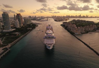 Tatilde olan bir yolcu gemisi. Gemi seyahati. Günbatımı denizinde seyahat et. Hava aracı manzaralı lüks bir yolcu gemisi. Gemi Miami limanından ayrılıyor. Seyahat güzergahı. Gemi seyahati.