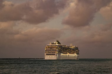 Gemi seyahati. Yaz tatilindeki deniz yolculuğunun havadan görünüşü. Denizlerde gemi turu. Gece vakti ışıltılı lüks yolcu gemisi yolculuğunun havadan görünüşü. Gemi Miami sahil limanından ayrılıyor. Gece hayatını dolaş..