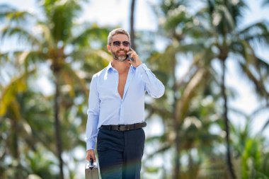 Telefona cevap veren adam. Sıradan bir iş adamı dışarıda telefonla konuşuyor. Telefon kullanan bir iş adamı. Erkek telefon konuşması. Akıllı telefonlu İspanyol bir iş adamı. İş iletişimi. Mobil konuşma.