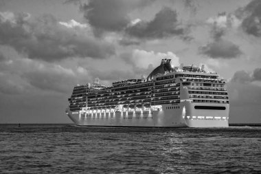 Gece vakti ışıltılı lüks yolcu gemisi yolculuğunun havadan görünüşü. Gemi Miami sahil limanından ayrılıyor. Gemi seyahati. Yaz tatilindeki deniz yolculuğunun havadan görünüşü. Gemi turu ve deniz yolculuğu..