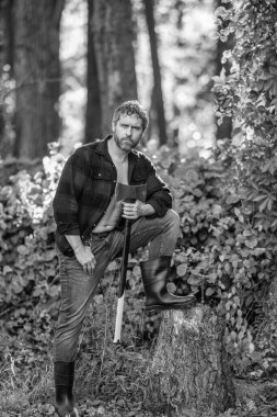 İspanyol adam lastik botlu baltayla kütük kesiyor. Oduncu baltası. Ağaç kesen baltalı adam. Çalışkan, acımasız adam. Keresteci adam dışarıda. Acımasız oduncu. Vahşilik ve erkeklik.