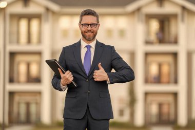 Başarılı bir komisyoncu. İpotek sigortacısı. Amerikalı satış müdürü. Satılık bir emlakçı. Takım elbiseli bir emlakçı. Kirala ya da yeni bir ev al. Ev sigortası. Emlak sigortası tanıtımı. Başparmak yukarı..