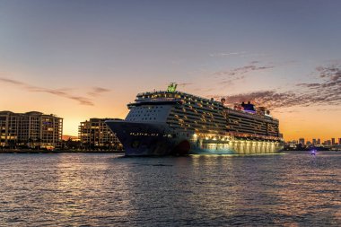 Miami, Florida, ABD - 24 Aralık 2024: Gemi gece aydınlandı. Norveç 'ten ayrılan yolcu gemisi yolculuğu. Yaz tatilinde gemi turu. Norveç yolcu gemisi. Gemi turu ve okyanus seyahati.