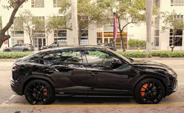 Miami, Florida, ABD - 08 Aralık 2024 Lamborghini Urus S SUV spor yara izi. Lamborghini Urus S tipi lüks bir spor araba. Lamborghini Urus 'un arabası dışarıda park edilmiş. Siyah Lamborghini Urus, yan görünüm.