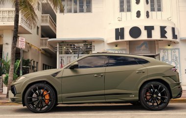 Miami, Florida, ABD - 08 Aralık 2024: Luxur yeşil renkli Lamborghini Urus S tipi spor araba. Lamborghini Urus 'un arabası dışarıda park halinde. Lamborghini Urus, yan görüş. 2024 Lamborghini Urus S SUV arabası.