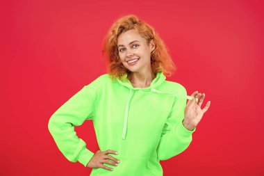 Çekici bir kadının şık bir görünüşü var. Kız havalı görünüyor. Minimum giysi. Pembe üzerine izole edilmiş kapüşonlu günlük kıyafetler giyen kızıl saçlı kadın. Yaşam tarzı konsepti. Kapüşonlu kadın model. Moda yeteneği..