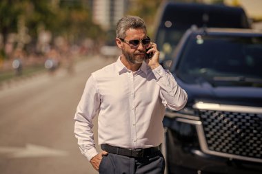 Telefon kullanan bir iş adamı. İş görüşmesi. Erkek telefon konuşması. Telefonu olan olgun bir İspanyol iş adamı. İş geliştirme. Müzakere çevrimiçi. İş adamı dışarıda telefonla konuşuyor..