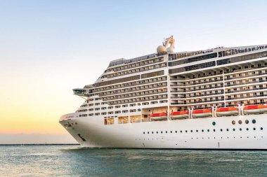 Miami, Florida, ABD - 21 Aralık 2024: MSC yolcu gemisi. Gemi turu ve deniz seyahati. Gemi gün batımında limandan ayrılıyor. MSC Divina yolcu gemisi yolculuğu. Yaz tatilinde gezmek.