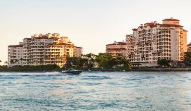 Marinaya yüzen bir tekne. Fisher Adası 'nda lüks bir yat teknesi. Yaz tatili. Fisher Adası konut binası ve lüks yat teknesi. Miami Fisher Adası Panorama Manzarası.