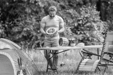 İspanyol adam kamp yapıyor. Karpuz kampı pikniği. Lezzetli sağlıklı yiyecekler. Kampta taze yiyecek. Yaz kampında karpuzlu bir adam. Yaz günü doğa yürüyüşçüsü. Kamp ve doğa pikniği.