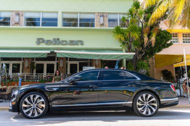 Miami, Florida, ABD - 27 Temmuz 2025 Bentley Flying Spur 2020 lüks sedan araba. Lüks araba Bentley Uçan Mahmuz. Araba Bentley Uçan Mahmuz dışarı park etmiş. Siyah araba, yan görüş..