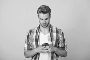 Telefon görüşmesi. Mobil iletişim. İletişim. Akıllı telefondan mesaj atan adam sarıda izole edilmiş. Millennial 'daki adam mesajlaşmak için telefonu kullanıyor. İnternette sohbet ediyoruz. Akıllı telefondan mesaj atan adam.