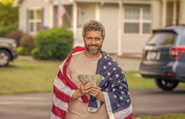 Amerika 'da vergi ödemek. Katma değer vergisi. Vergi sistemi. Vatansever adam. Amerikan bayrağı ve dolar parası olan adam. Enflasyon konsepti. Amerikan vergi politikası. İspanyol adam ve Amerikan bayrağı. ABD 'de maaş.