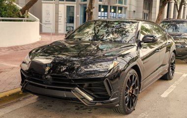 Miami, Florida, ABD - 08 Aralık 2024 Lamborghini Urus S SUV spor yara izi. Lamborghini Urus S tipi lüks bir spor araba. Lamborghini Urus 'un arabası dışarıda park edilmiş. Siyah Lamborghini Urus, köşe manzaralı..