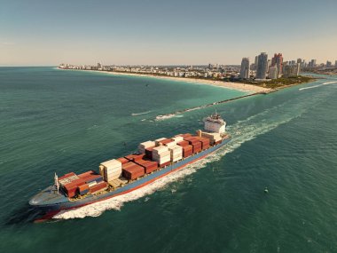 Denize bakan kargo gemisi. Kargo işi. Konteyner gemisi. Nakliye lojistiği. Ticari nakliye. Kargo gemisi denizde, hava manzaralı. Yük konteynırı kargo gemisine yüklendi.