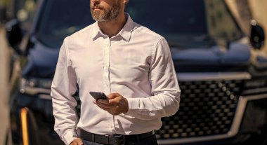 İş adamı yürüyor. Şirket işi. Dışarıdaki telefonda iş adamı sohbeti. İş adamı telefonda sohbet ediyor. Akıllı telefon kullanan bir iş adamı. Çevrimiçi yakışıklı iş adamı sohbeti, kırpılmış manzara.